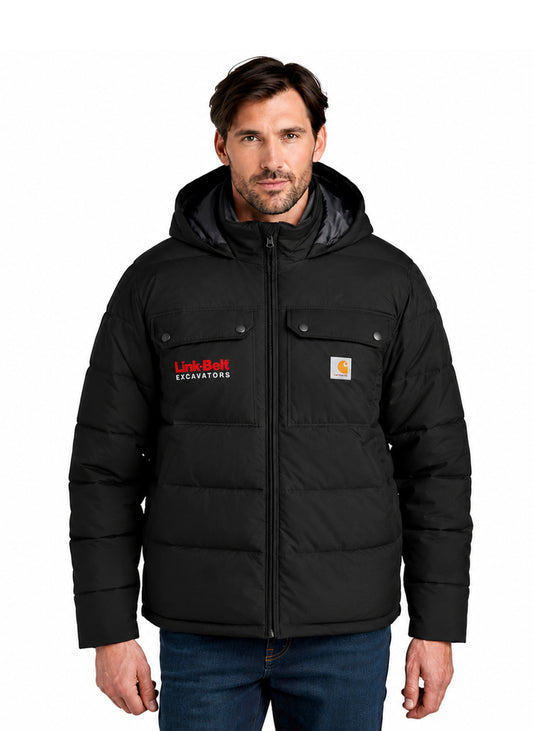 A man wearing a black hooded puffer jacket with a full zipper, snap-flap chest pockets, and visible Carhartt and Link-Belt Excavators logos, paired with blue jeans against a plain white background.